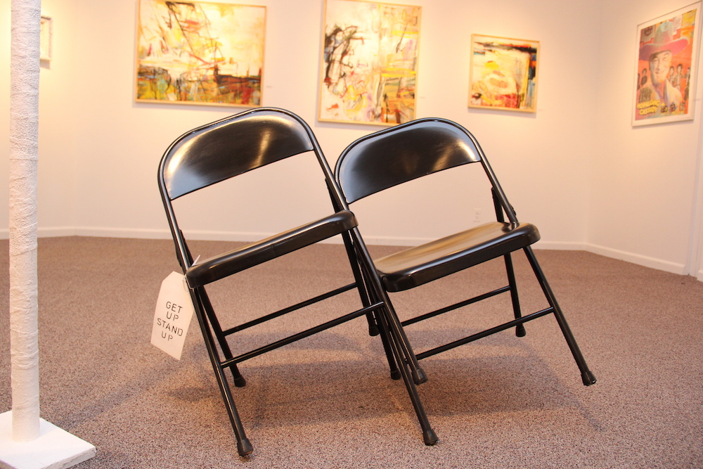 Two metal folding chairs leaning against one another